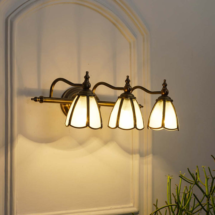 Orb 3 lights mirror light in brass ant finish with frosted glass shades.