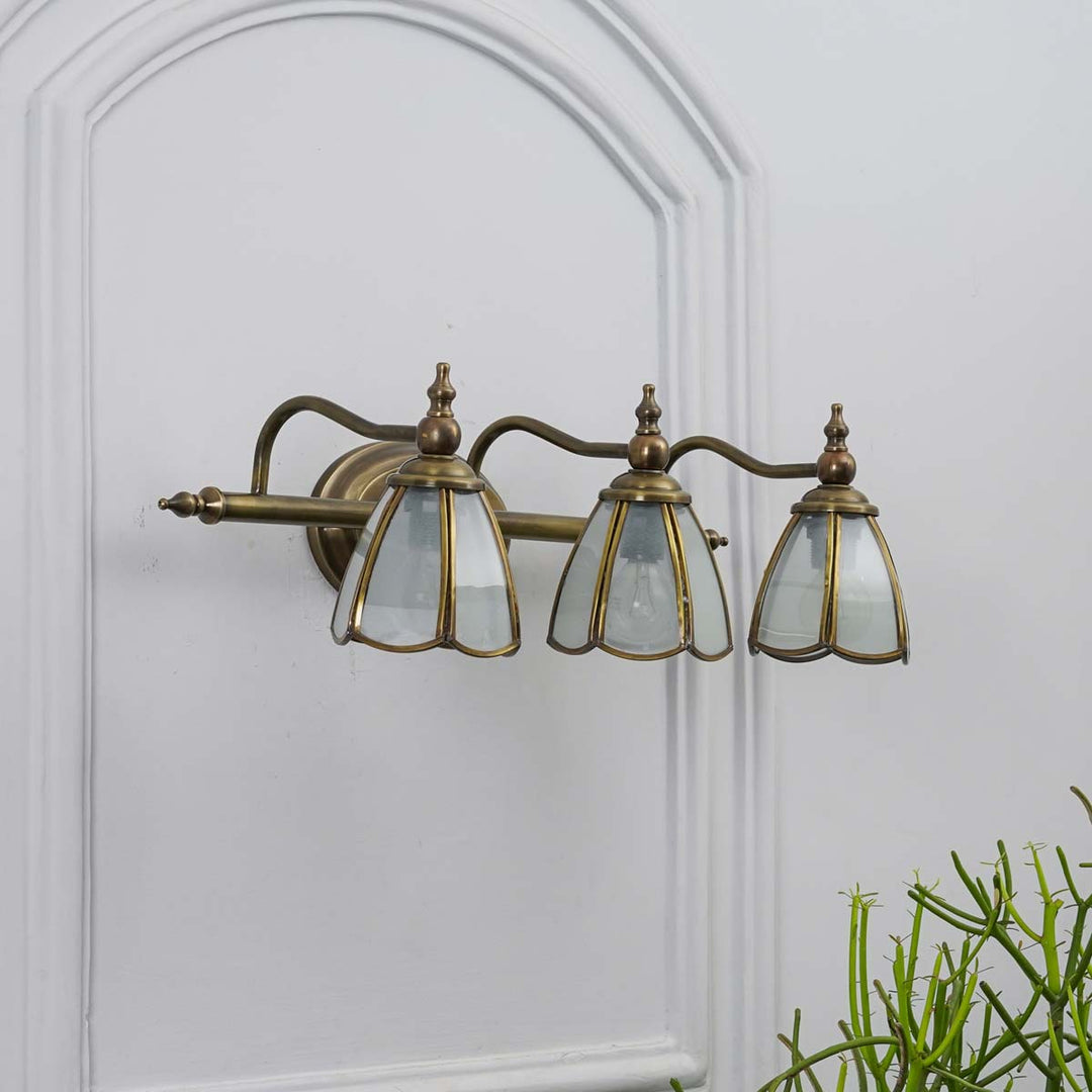 Orb 3 lights mirror light in brass ant finish with frosted glass shades.