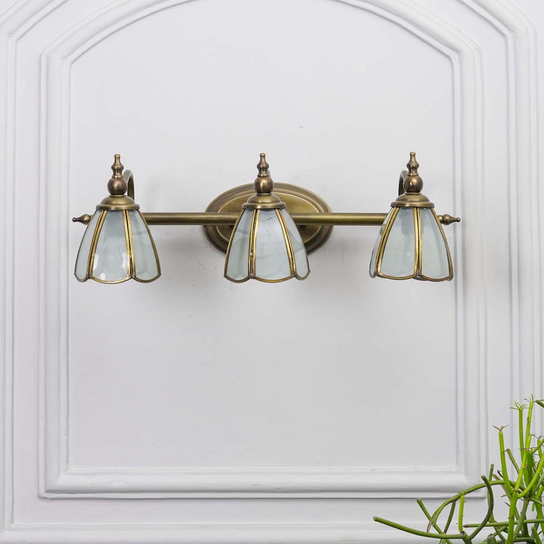 Orb 3 lights mirror light in brass ant finish with frosted glass shades.