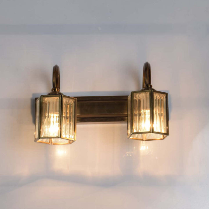 Neptunus 2 lights mirror light in brass ant finish with frosted glass shades.