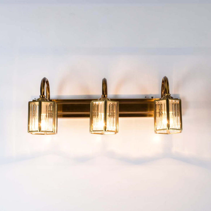 Nagoya 3 lights mirror light in brass ant finish with frosted glass shades.