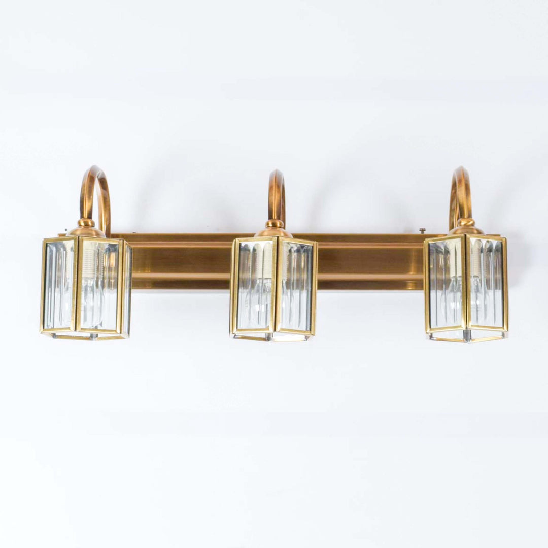 Nagoya 3 lights mirror light in brass ant finish with frosted glass shades.